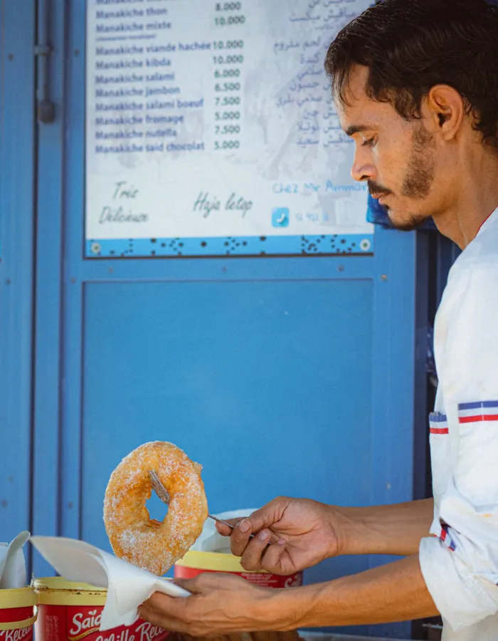 Vendor serving a fresh doughnut